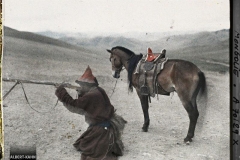 Chasseur mongol descendu de cheval faisant une démonstration du maniement du fusil à pierre, Aux environs d'Ourga, Mongolie, 20 juillet 1913, (Autochrome, 9 x 12 cm), Stéphane Passet, Département des Hauts-de-Seine, musée Albert-Kahn, Archives de la Planète, A 70 129 XS