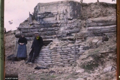 Un couple prend la pose devant un bunker recouvert de tronc d'arbres, Chemin des Dames, Aisne, France, Sans date, (Autochrome, 9 x 12 cm), opérateur non mentionné, Département des Hauts-de-Seine, musée Albert-Kahn, Archives de la Planète, A 74 355